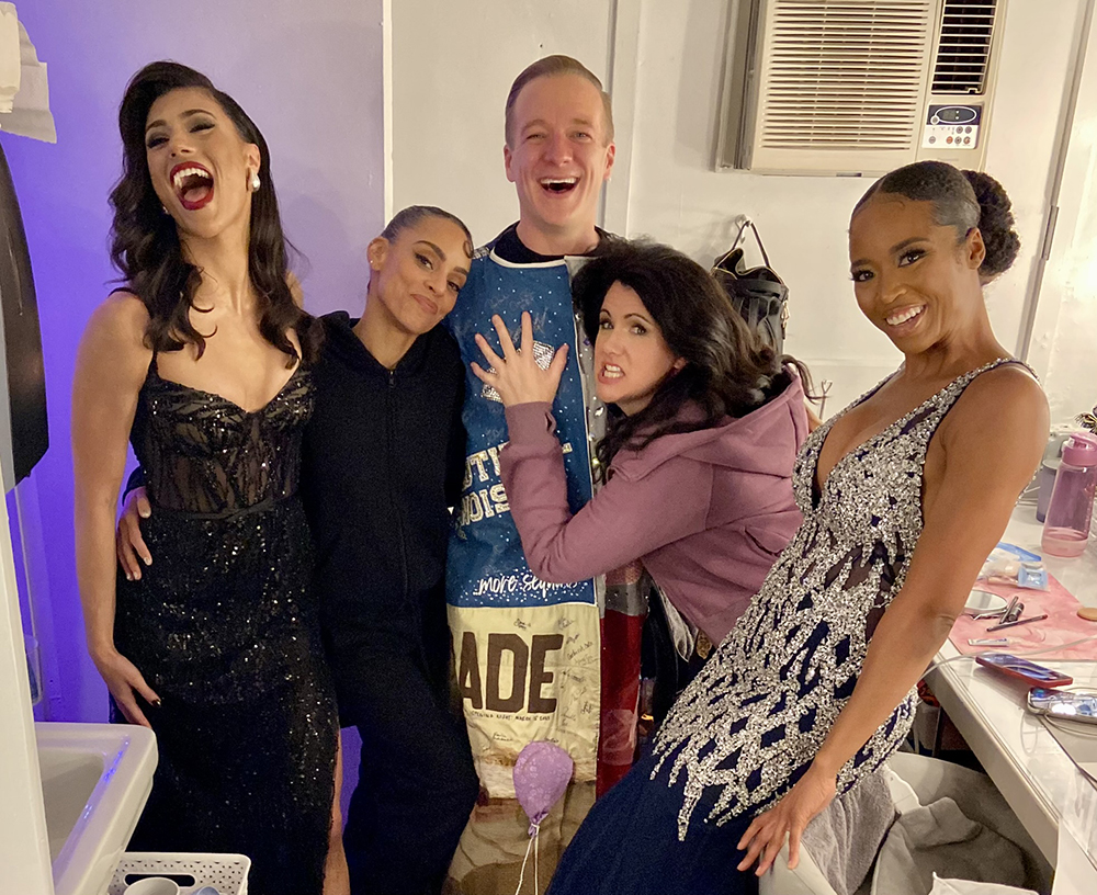 A group of five people, including Worsing in the middle in the Robe, pose backstage, either looking happy or making a silly face.
