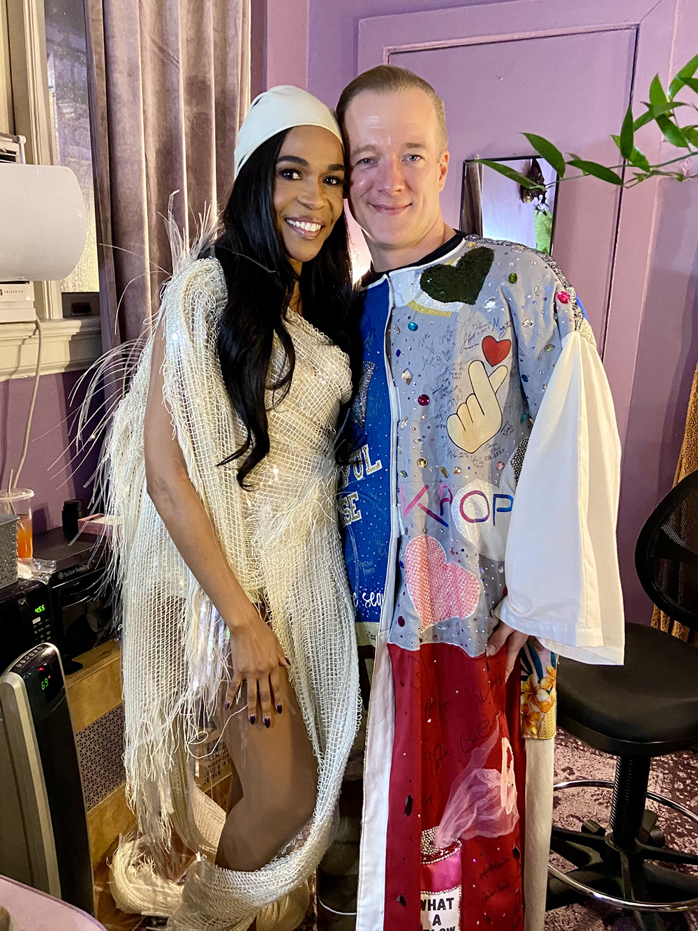 Michelle Williams and Ryan Worsing (in the Robe) pose and smile together in a dressing room.