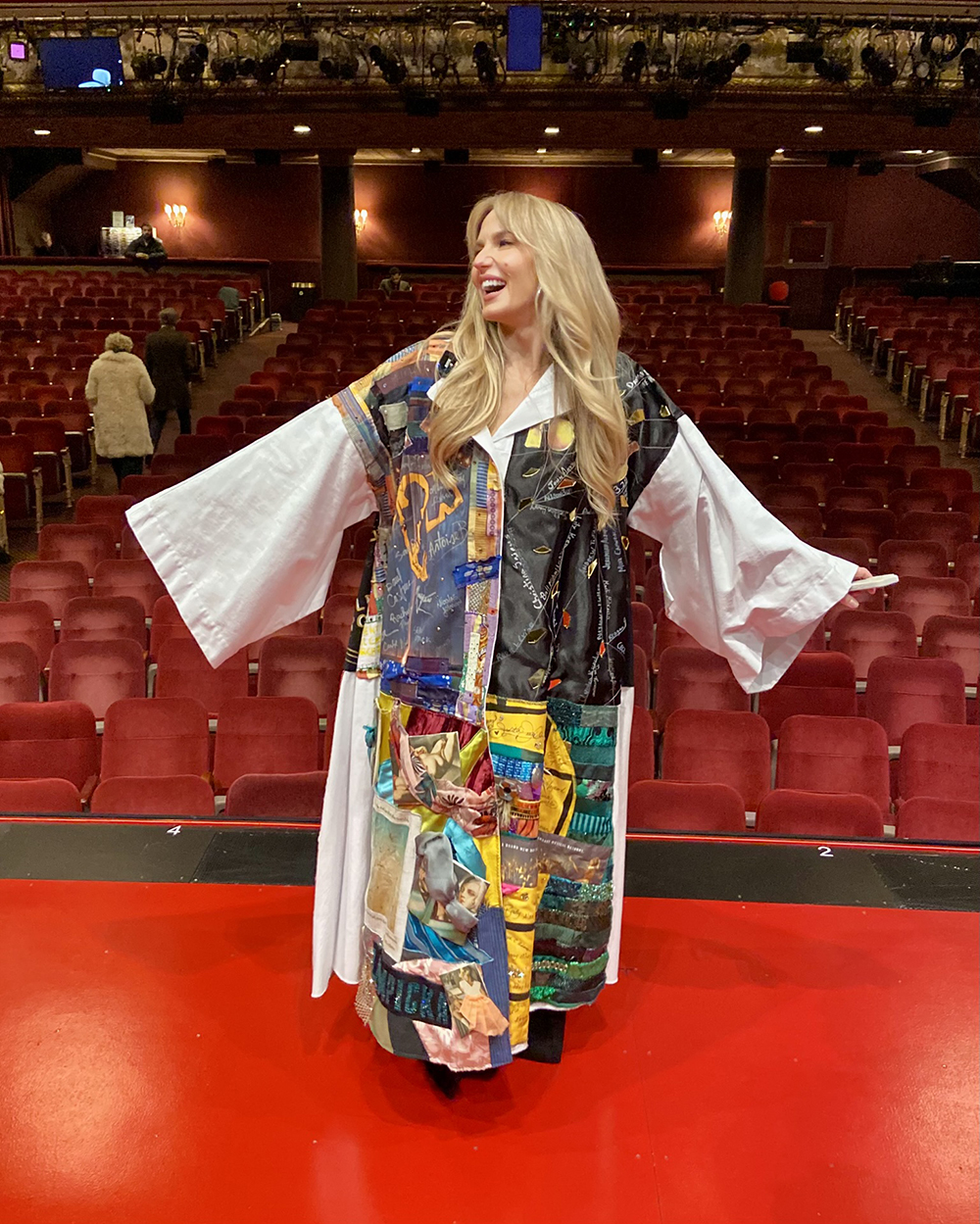 Katie Webber poses in the Robe onstage, the house visible behind her.