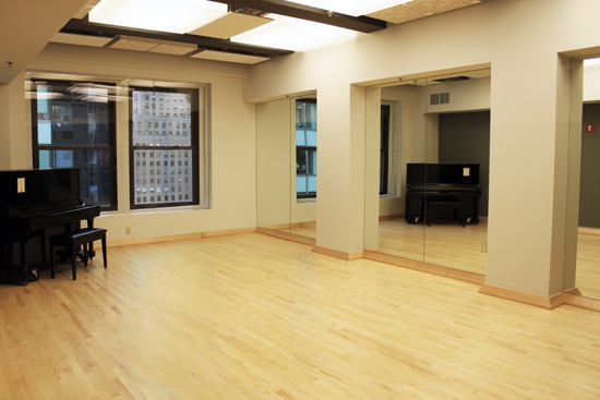 Studio B has an upright piano, wood floor, and mirrors.